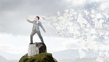 Smiling businessman talking on yellow phone handsetの写真素材