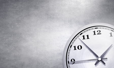 Round wall clock hanging on grey concrete wallの写真素材