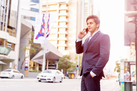 Portrait of confident businessman with his mobile phone outdoorsの写真素材