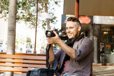 Professional photographer taking picture in cityの写真素材