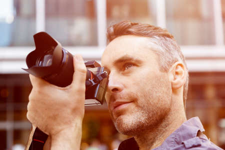 Professional photographer taking picture in cityの写真素材