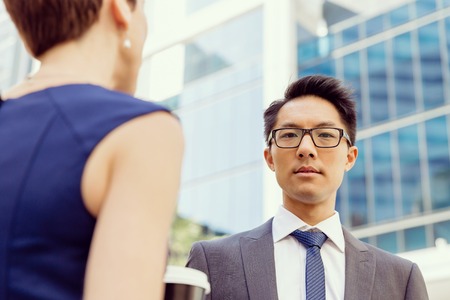 Business people having a talk while walking in a businesss districtの写真素材