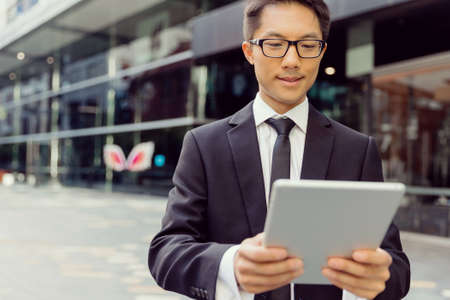 Businessman in city holding his notebookの写真素材