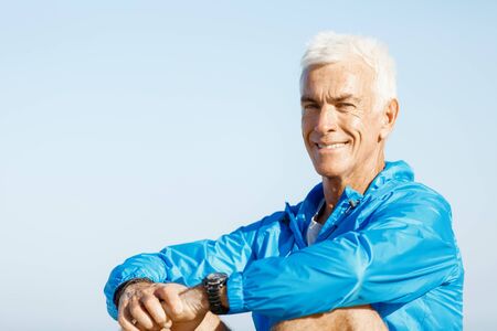Man in sports wear sitting alone at the beach and having minute of restの写真素材