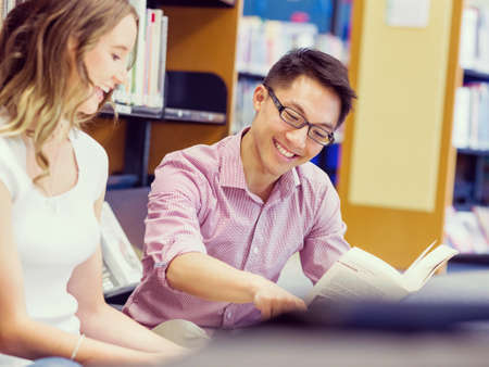 Two young students working together at the library