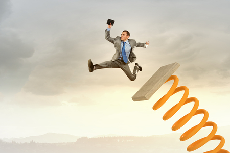 Businessman jumping on springboard as progress conceptの写真素材