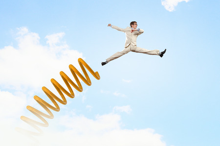 Businessman jumping on springboard as progress conceptの写真素材