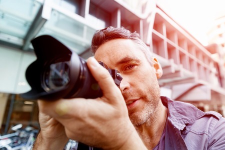Professional photographer taking picture in cityの写真素材