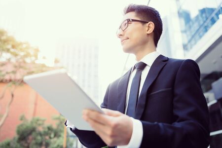 Businessman in city holding his notebookの写真素材