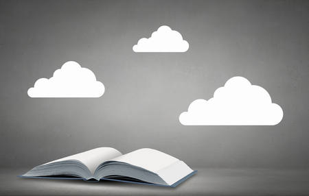 Opened book with white clouds above pagesの写真素材