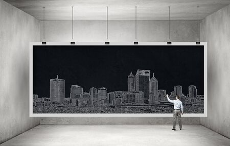 Rear view of man engineer drawing on chalkboardの写真素材