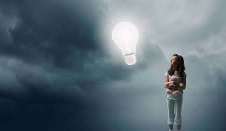 Cute girl wearing pajamas with toy bear in handの写真素材