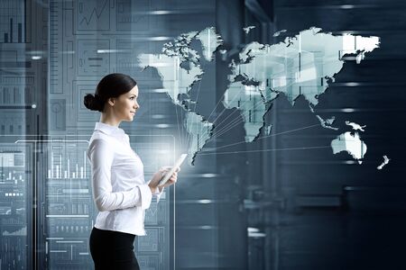 Businesswoman with tablet pc against high tech blue backgroundの写真素材