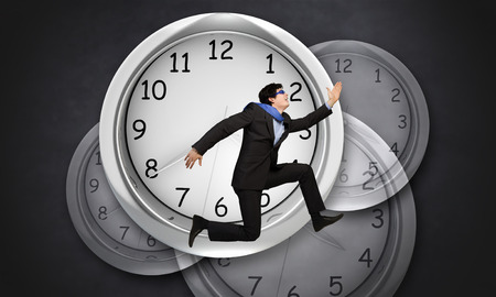 Concept of time with funny businessman running in a hurryの写真素材