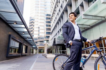 Successful businessman in suit riding bicycleの写真素材