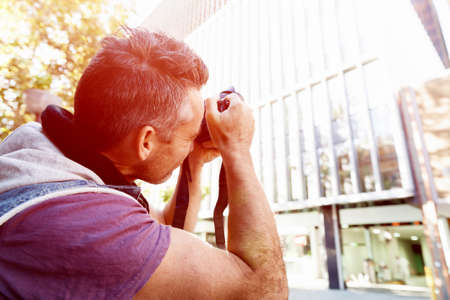 Professional photographer taking picture in cityの写真素材