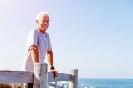 Man standing on beach in sports wear looking fit and happyの写真素材