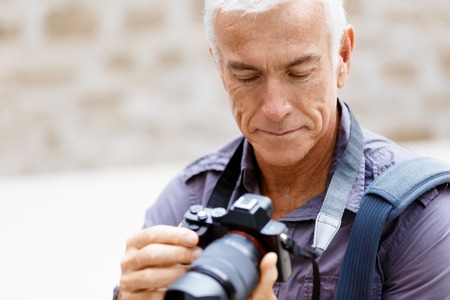 Senior man with camera in cityの写真素材