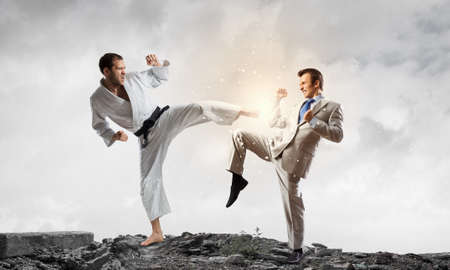 Young determined karate man fighting with businessman in suit
