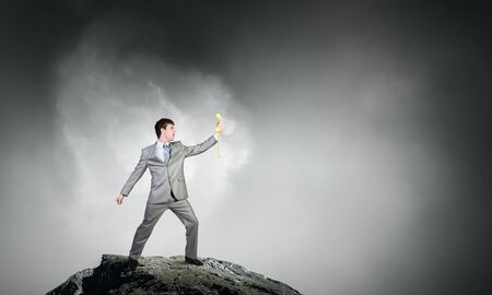 Smiling businessman screaming in yellow phone handsetの写真素材