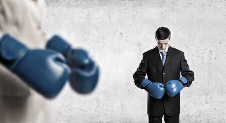 Determined businessman in suit and boxing gloves