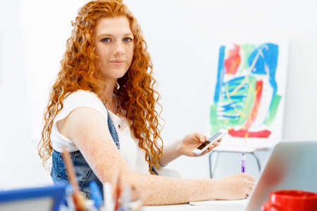 Young business woman in office holding mobile phoneの写真素材