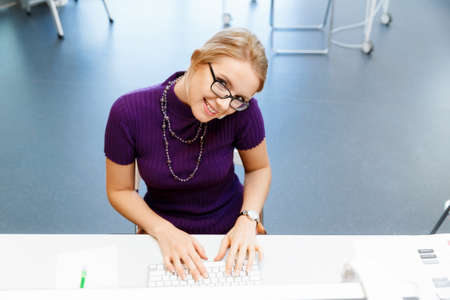Young business woman in office holding mobile phoneの写真素材