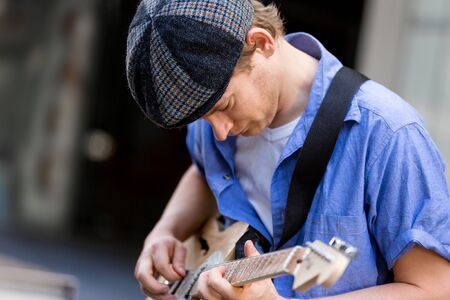 Portrait of young musician with guitar in cityの写真素材