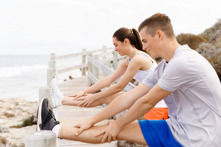 Runners. Young couple doing sport on beach togetherの写真素材