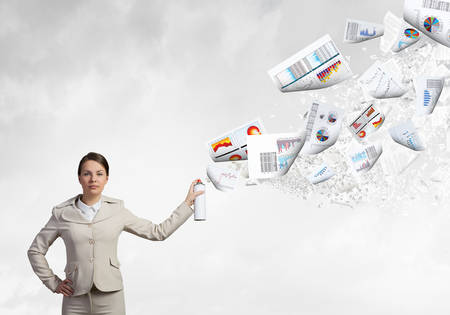 Young woman in suit with suitcase spraying paper sheetsの写真素材