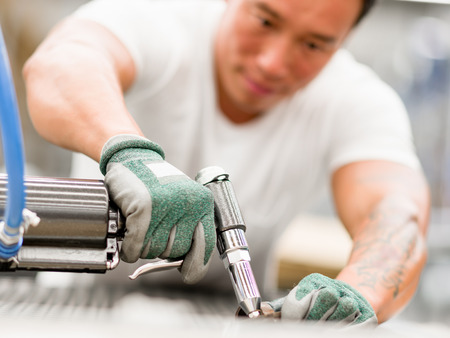 portrait of asian worker in production plant working on the factory floor