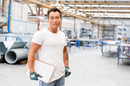portrait of asian worker in production plant working on the factory floor