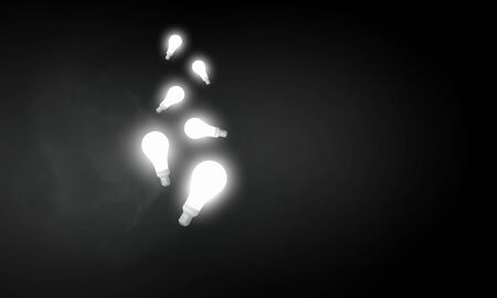 Illuminated glass light bulb on dark backgroundの写真素材