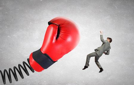 Young determined businessman fighting boxing glove on springの写真素材