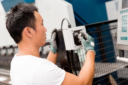 portrait of asian worker in production plant working on the factory floor