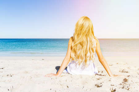 Portrait of young pretty woman relaxing on sandy beachの写真素材