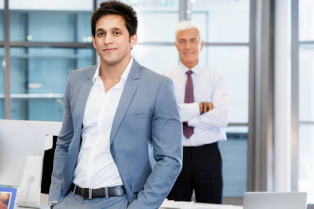 Portrait of businessman with collegue on backgroundの写真素材