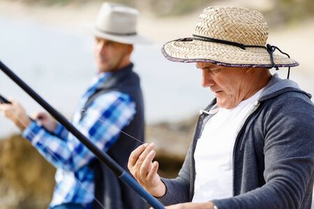 Picture of fishermen fishing with rodsの写真素材