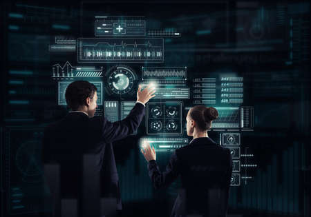 Rear view of businessman and businesswoman working with virtual panel interface