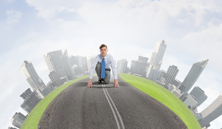 Young businessman standing in start position ready to competeの写真素材
