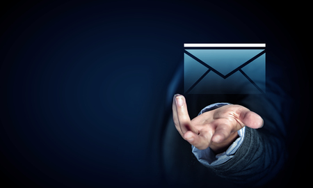 Close up of businessman palm holding email icon on dark backgroundの写真素材