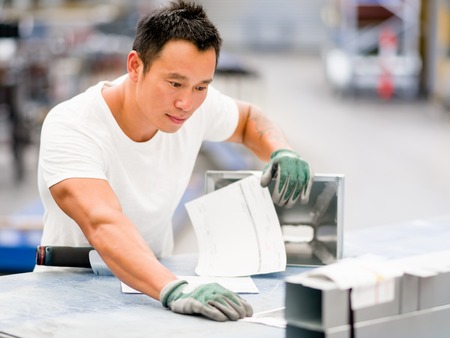portrait of asian worker in production plant working on the factory floorの写真素材