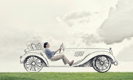 Young humorous woman driving drawn funny carの写真素材