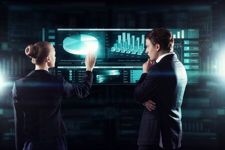 Rear view of businessman and businesswoman working with virtual panel interface