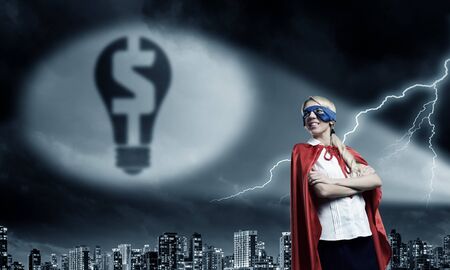 Young woman super hero and dollar sign in spotlightの写真素材