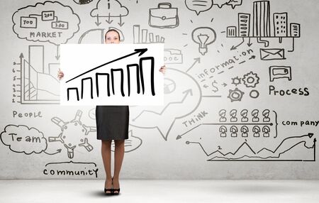 Businesswoman holding white banner with growing arrow graphの写真素材