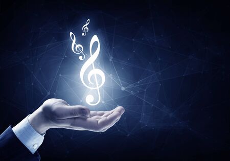 Close up of hand holding music icon in palmの写真素材