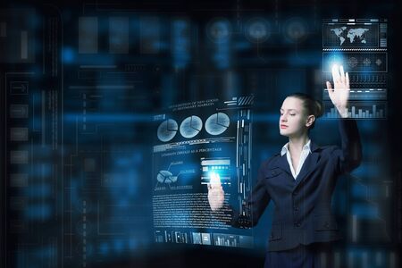 Attractive smiling businesswoman working with virtual panel interface