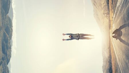 Young businessman making jump between two realitiesの写真素材