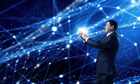 Businessman using his smartphone on background of connection linesの写真素材